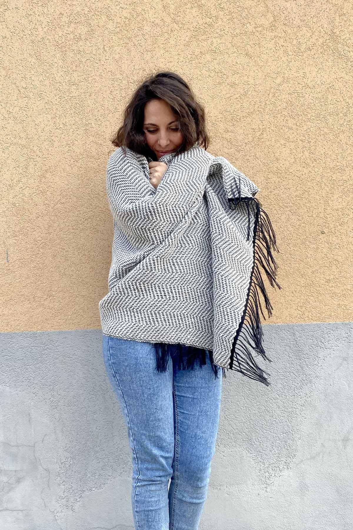 Flavia Amato indossa Ampio scialle Agata telaio manuale calabrese filati recupero bianco strisce nero malia lab atelier moda etica sostenibile artigianale accessori artigianali